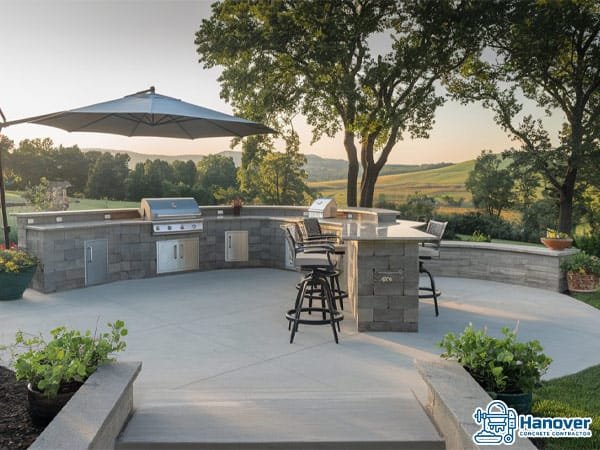Concrete patio with a fully equipped outdoor kitchen and bar seating.